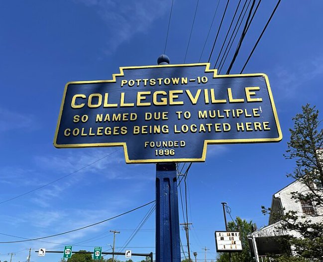 Historic Collegeville town sign against a blue sky